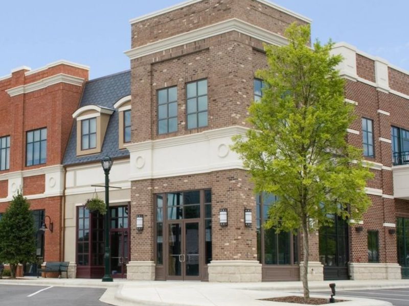 Three-story brick mixed-use commercial building at a street corner