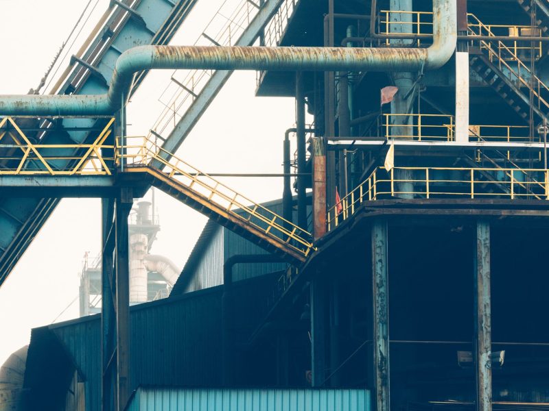Industrial conveyor structure with steel stairs and safety railings